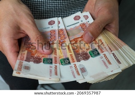 Close-up men's hands hold a wad of Russian money five thousand bills. Royalty-Free Stock Photo #2069357987