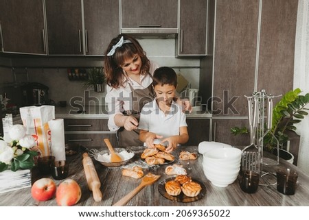 Mom and child prepare a birthday cake in the kitchen for Mother's Day, a series of pictures of everyday lifestyle in the interior from real life