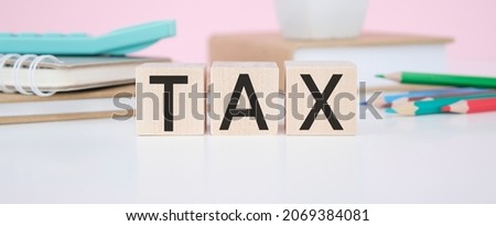 Tax- text on wooden cubes on the wooden background, Tax Concept with wooden blocks