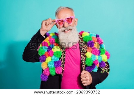 Photo of funky cool senior hipster wear handmade pop-pom blazer arm eyeglasses smiling isolated teal color background Royalty-Free Stock Photo #2069390732