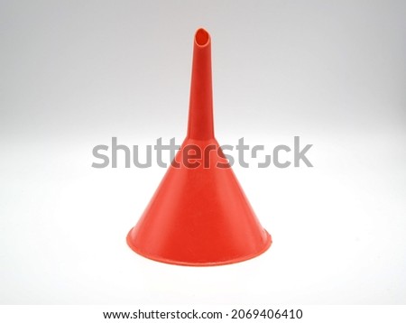 Red plastic funnel on white background