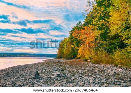 Autumn landscape, bright colorful leaves on the rocky riverbank.
