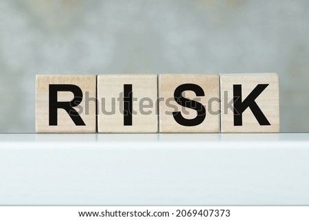 Risk word on a wooden cubes on the table in isolation. Business, risk vs rise concept.
