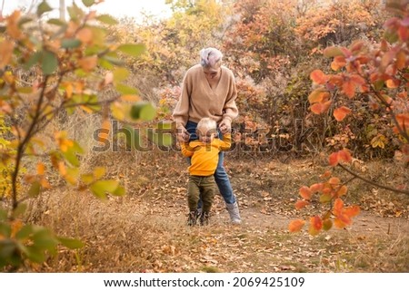 Family in autumn forest. Mom playing with son child