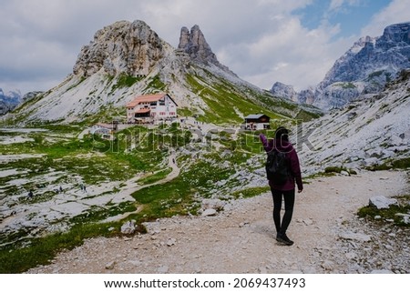 Tre Cime di Lavaredo peaks or Drei Zinnen at sunset, Dobbiaco Toblach, Trentino -Alto Adige or South Tyrol, Italy. Europe Alps. Asian woman hiking in the mountains Royalty-Free Stock Photo #2069437493