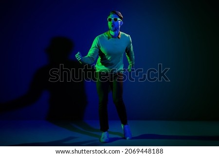 Full length photo of young man amazed surprised excited have fun hipster dance club isolated over dark color background