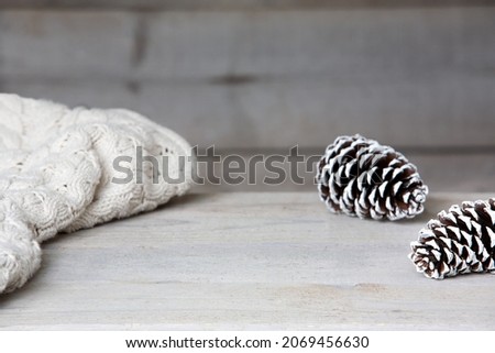 Rustic table mockup background with blanket and pine cones. Winter or fall scene with empty space for product mockup.