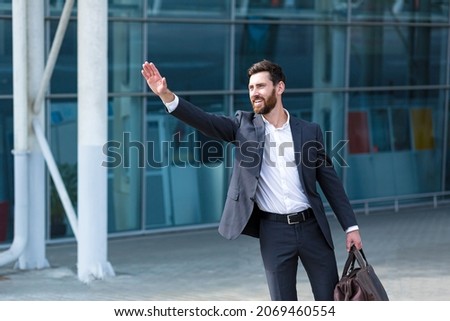 Male businessman can not catch free taxi at busy time. business man does not successfully stop a taxi on a city street. can't catch a car on the road waving his hand. standing on the sidewalk outside
