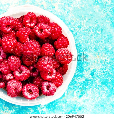 Raspberry fruit background over colorful beautiful textured  background macro. Summer or Spring Natural Berry 