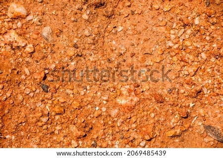 Reddish clay soil, small stones, full-frame