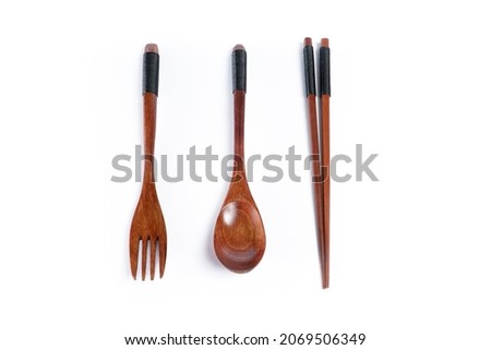 A pair of wooden spoon, fork, and chopsticks with a rope wrapped around the handle isolated on white background. Top view. Close up.