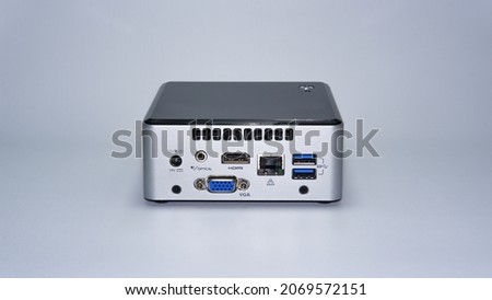 Mini desktop personal computer with HDMI, VGA, 2 x USB 3.0, LAN, audio port, and 19 Volt DC power supply, silver plastic case, white background isolated Royalty-Free Stock Photo #2069572151