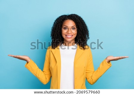 Photo of young black woman happy positive smile hold hands product promo ads isolated over blue color background Royalty-Free Stock Photo #2069579660