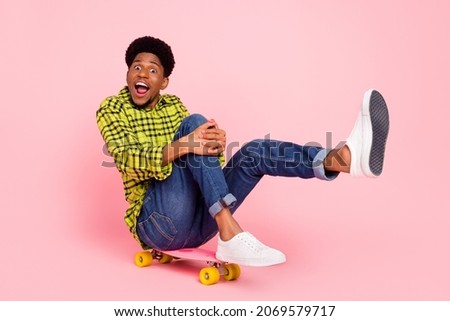 Full size photo of millennial funky brunette guy ride board wear shirt jeans sneakers isolated on pink background