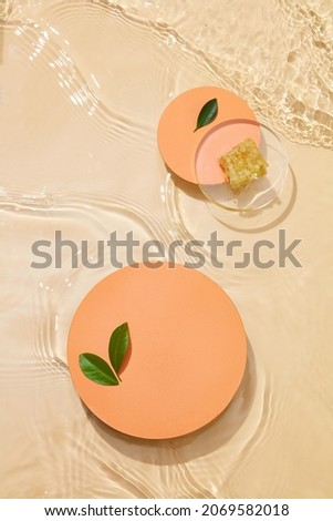 Transparent wheat colored clear water surface texture with ripples, splashes and bubbles , orange podium Abstract wheat background Water waves in sunlight with blank space for cosmetic advertising