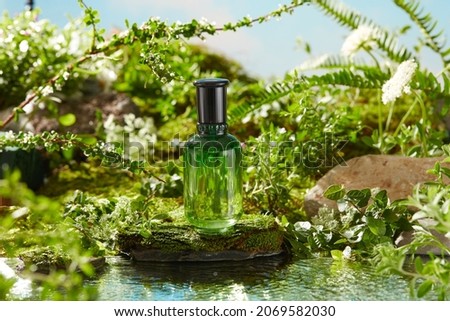 Front view of green cosmetic jar in a garden with flower , green leaf rocks bright daylight background , reflection of a lake photography nature conconcept