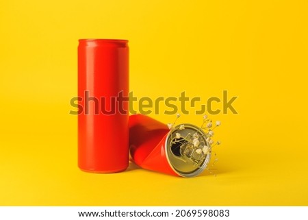 Cans of soda with flowers on color background