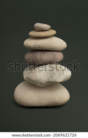 Marble zen stones stacked on green background in stability concept