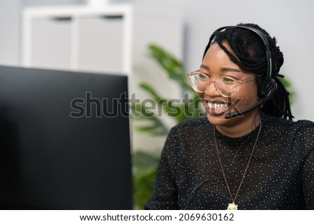 Customer service agent, financial advisor call center employee sits at desk in company in front of computer screen, headphones with microphone on ears, connecting with caller, solving problem Royalty-Free Stock Photo #2069630162
