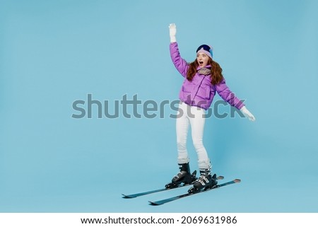 Full body skier beginner fun cool woman wearing warm purple padded windbreaker jacket ski goggles mask spend extreme weekend in mountains skiing leaning back isolated on plain blue background studio. Royalty-Free Stock Photo #2069631986