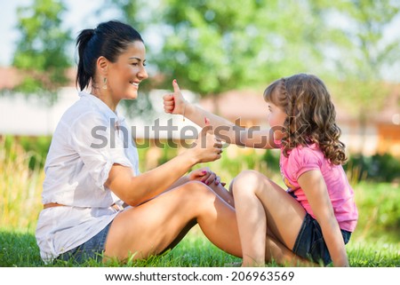 Mother and daughter in the park having fun