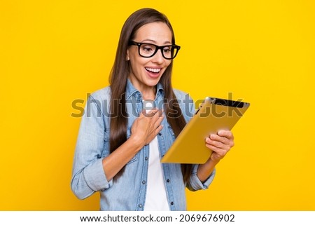 Profile side photo of young excited woman look tablet speak video meeting isolated over yellow color background