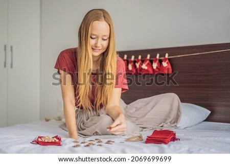 Woman making Christmas advent calendar. Pouches on a rope