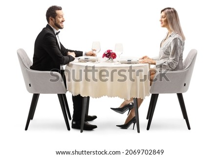 Young elegant man and woman sitting at a restaurant table isolated on white background Royalty-Free Stock Photo #2069702849