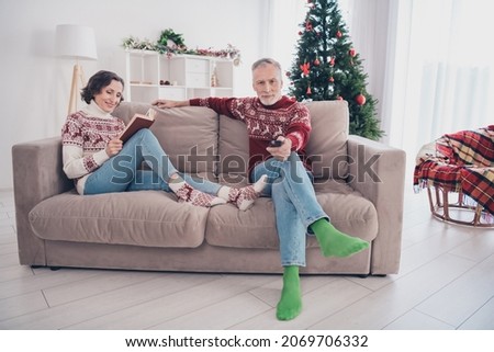 Full length photo of nice couple old lady man sit watch tv wear sweater jeans socks at home