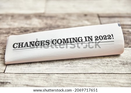 Changes coming in 2022 is written on the front page of a folded newspaper on a wooden table Royalty-Free Stock Photo #2069717651