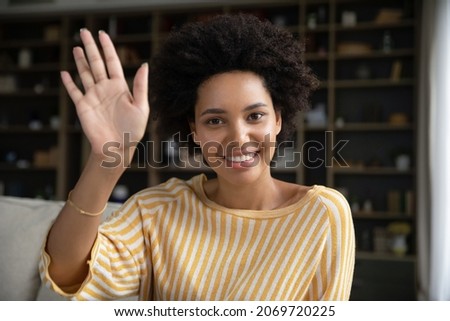 Head shot web camera view happy young African American woman waving hand, starting pleasant distant video call conversation, streaming online in social network, studying or working remotely Royalty-Free Stock Photo #2069720225