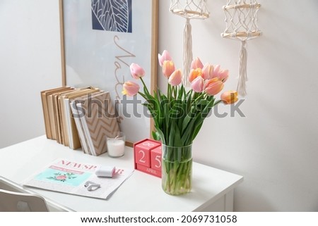 Bouquet of beautiful tulip flowers on table near white wall
