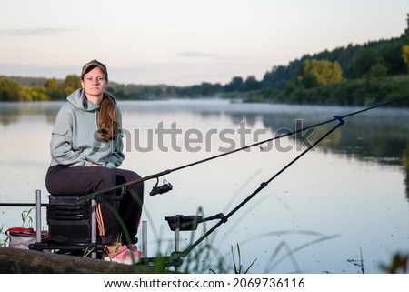 Girl, fisherman athlete, catches fish on the river