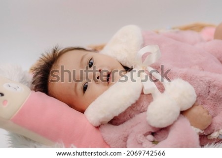 Cute small boy lying at bed. Childhood bath concept. Light background. Little child. Serious emotion. Copyspace. Stay home. Towel mockup. Closed eyes. Horizontal banner
