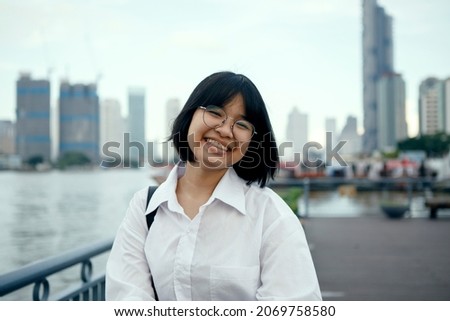asian teenager toothy smiling with happiness face ,standing at city outdoor