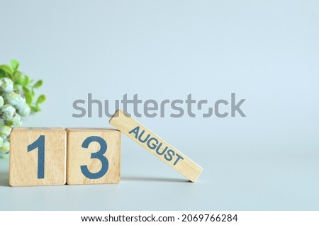 August 13, Calendar cover design with number cube with green fruit on blue background.