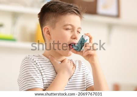 Little boy with inhaler having asthma attack at home Royalty-Free Stock Photo #2069767031