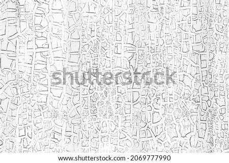 Grunge white wall with cracked peeling paint, close-up background photo texture