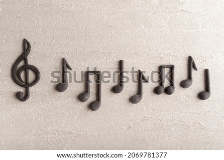 Black music violin clef sign and note on rough beige surface. G-clef. Treble clef. Close up. Royalty-Free Stock Photo #2069781377