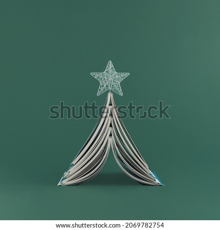 2023. Minimal abstract creative New Years scene with silver star and Christmas tree made with books, on isolated green background. Xmas greeting card or contemporary gift card. Education concept. Royalty-Free Stock Photo #2069782754