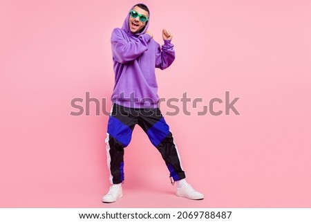 Full size photo of funky millennial brunet guy dance wear eyewear hoodie pants shoes isolated on pink background