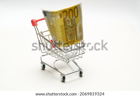 European currency. 200 (Two hundred) Euro in shopping cart on a white background. High quality photo Royalty-Free Stock Photo #2069819324