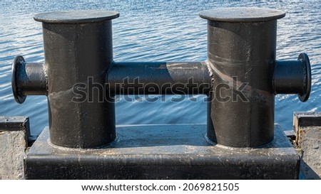 a device for mooring ships. advertising picture. large-sized bollard. a product made of iron. black color.