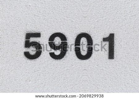 Black Number 5901 on the white wall. Spray paint. Number five thousand nine hundred one.
