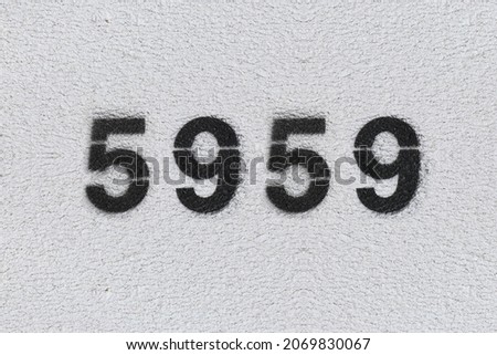 Black Number 5959 on the white wall. Spray paint. Number five thousand nine hundred fifty nine.