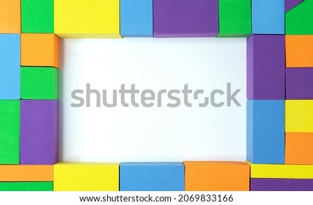 Frame of multi-colored squares, rectangles and triangles with a white middle.
