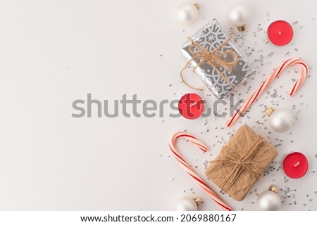 Festive composition on a white background. Lollipops, gifts, candles, silver confetti. New Year, Christmas, Valentine's Day. Birthday, family holidays and celebrations.