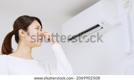 Air conditioner and Asian woman Royalty-Free Stock Photo #2069902508