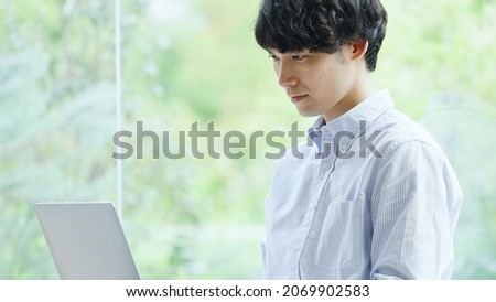 Asian young man working with a computer Royalty-Free Stock Photo #2069902583