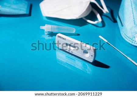 Close up image of Rapid test kit device for Covid-19 showing positive result. Lab card kit test for coronavirus SARS-CoV-2 virus. Fast test COVID-19 on blue surface Royalty-Free Stock Photo #2069911229